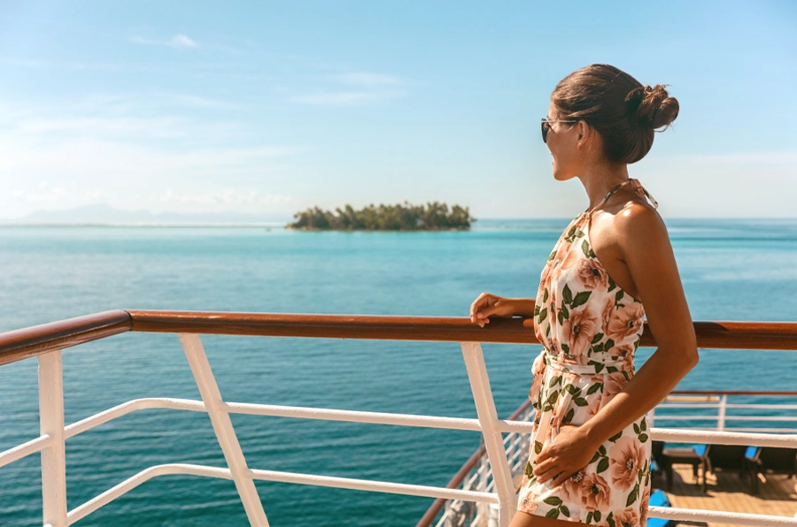 weekend caribbean cruises woman looking off of boat to small island trees