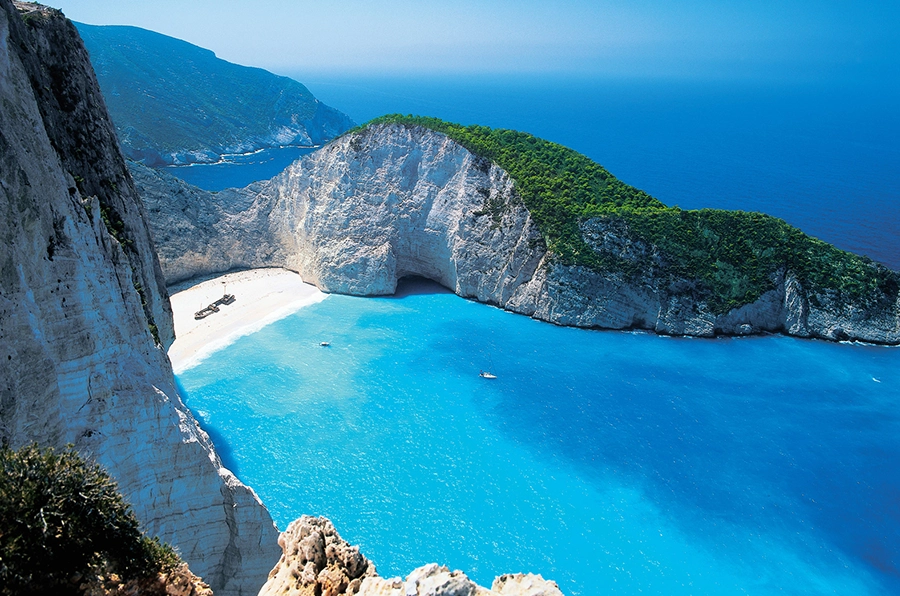 mediteranean ocean with two islands inbetween beach shore